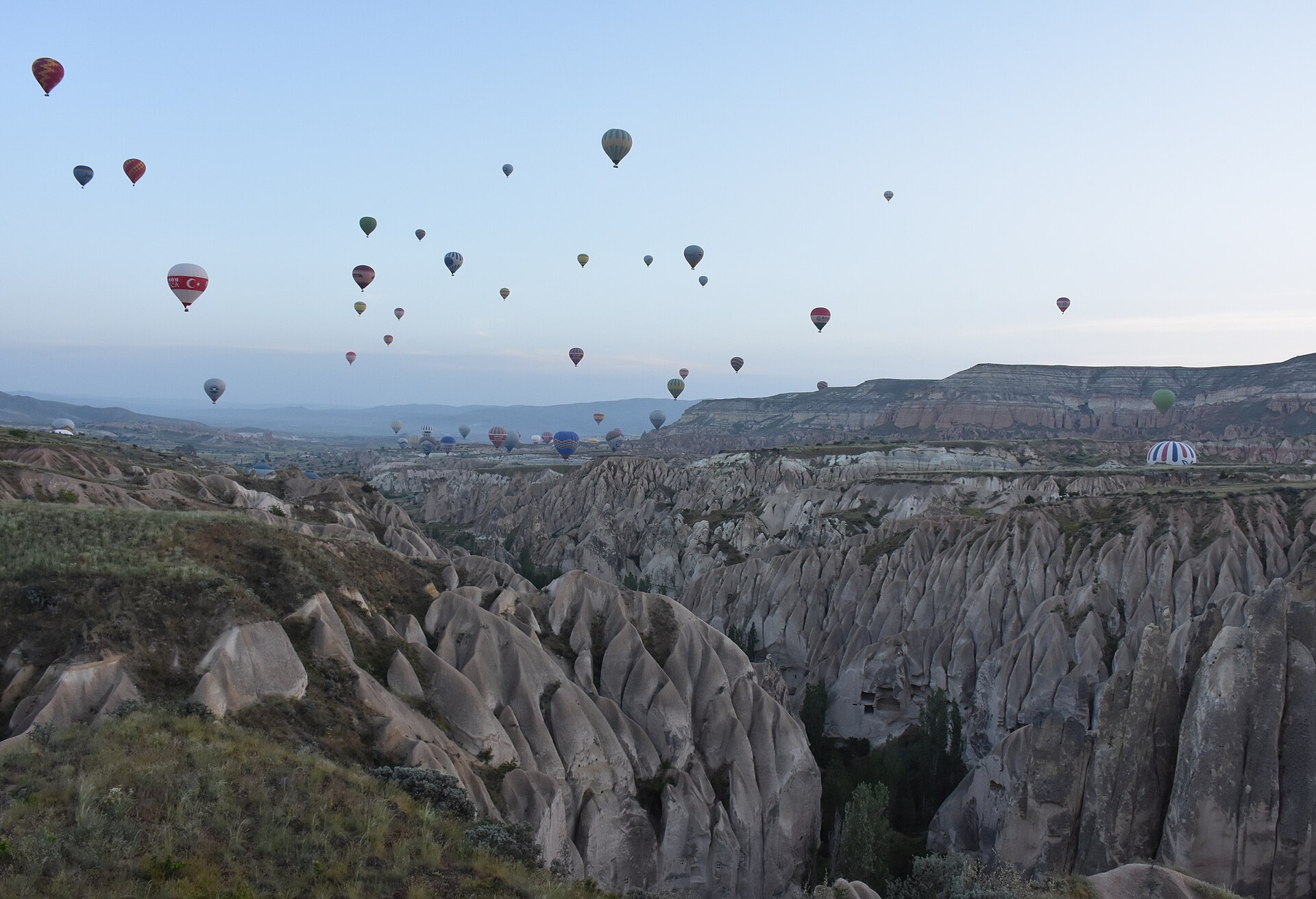 Hot air balloons rising over the valleys near Goreme in Cappadocia at dawn