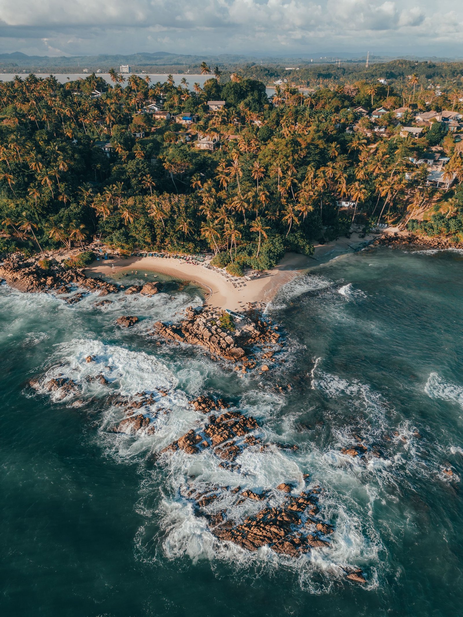 Aerial view of Mirissa Beach and its palm-lined coast in Sri Lanka